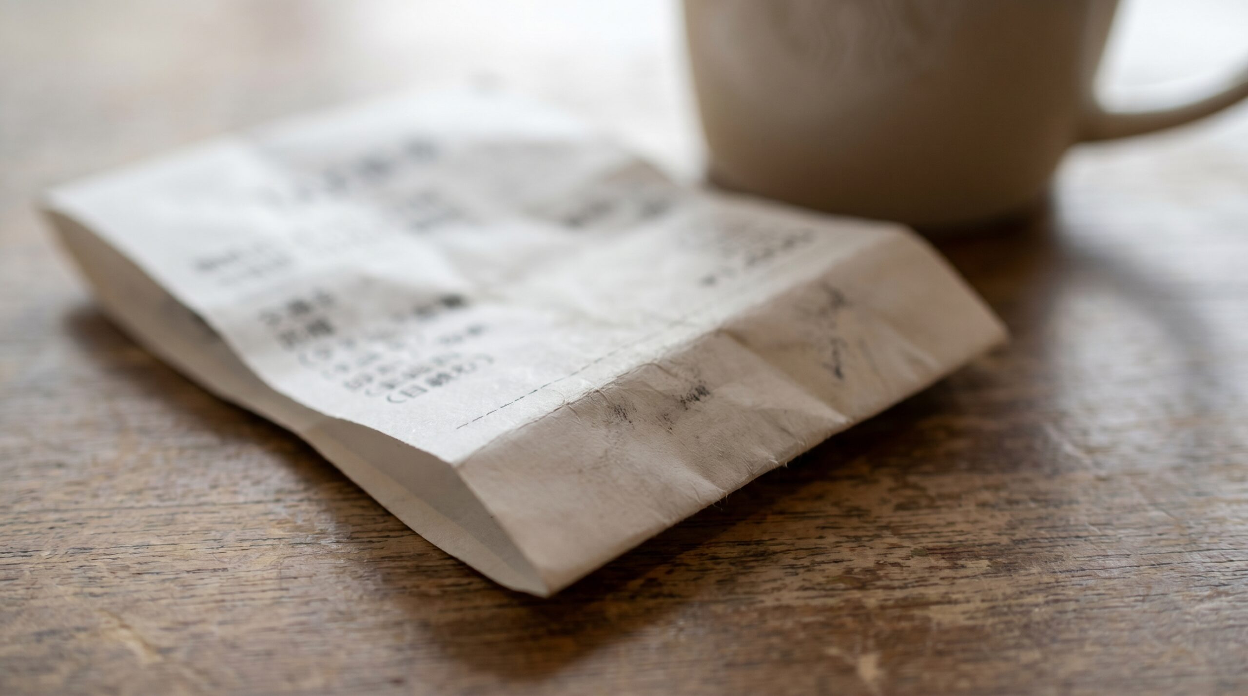 Folded Japanese taxi receipt on a wooden table