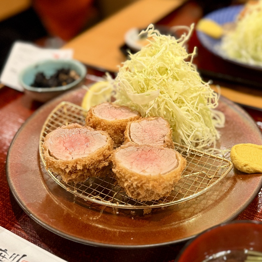 Premium hire katsu with rare pink interior served on a wire mesh plate (illustrative image)
