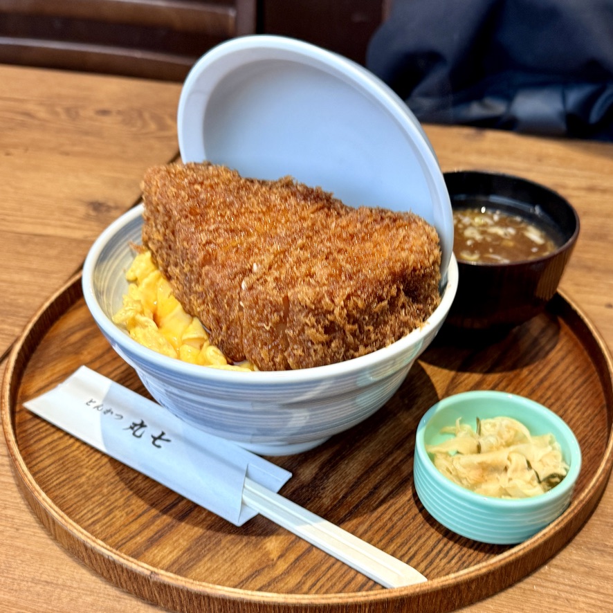 Katsudon: pork cutlet simmered with egg and onion over rice in a covered bowl (illustrative image)