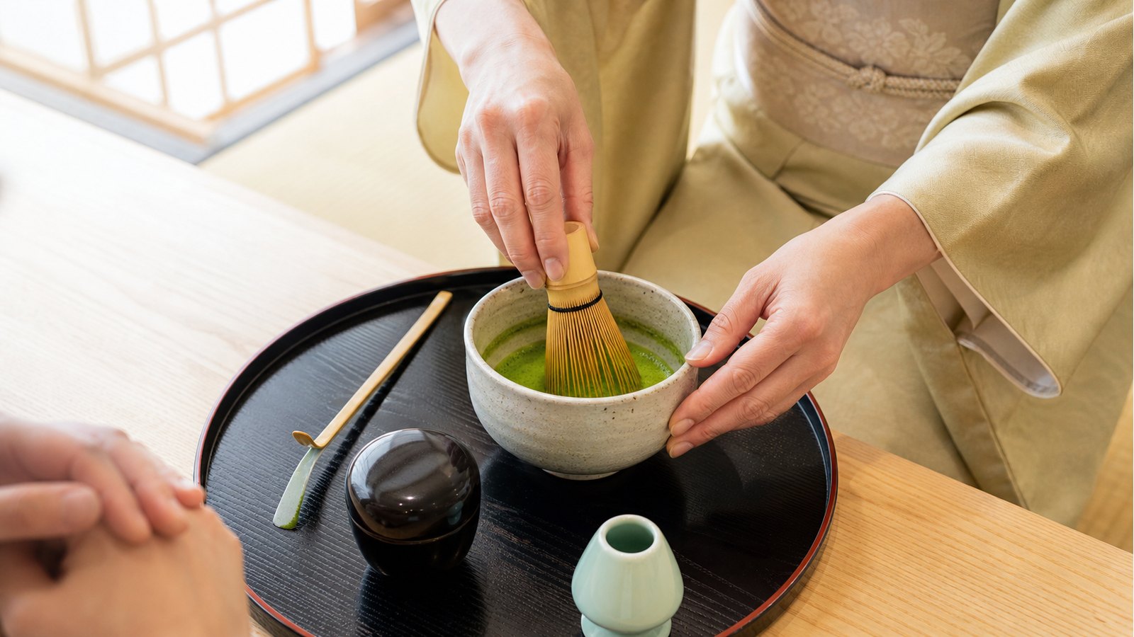 Instructor hands whisking matcha during a beginner tea ceremony experience