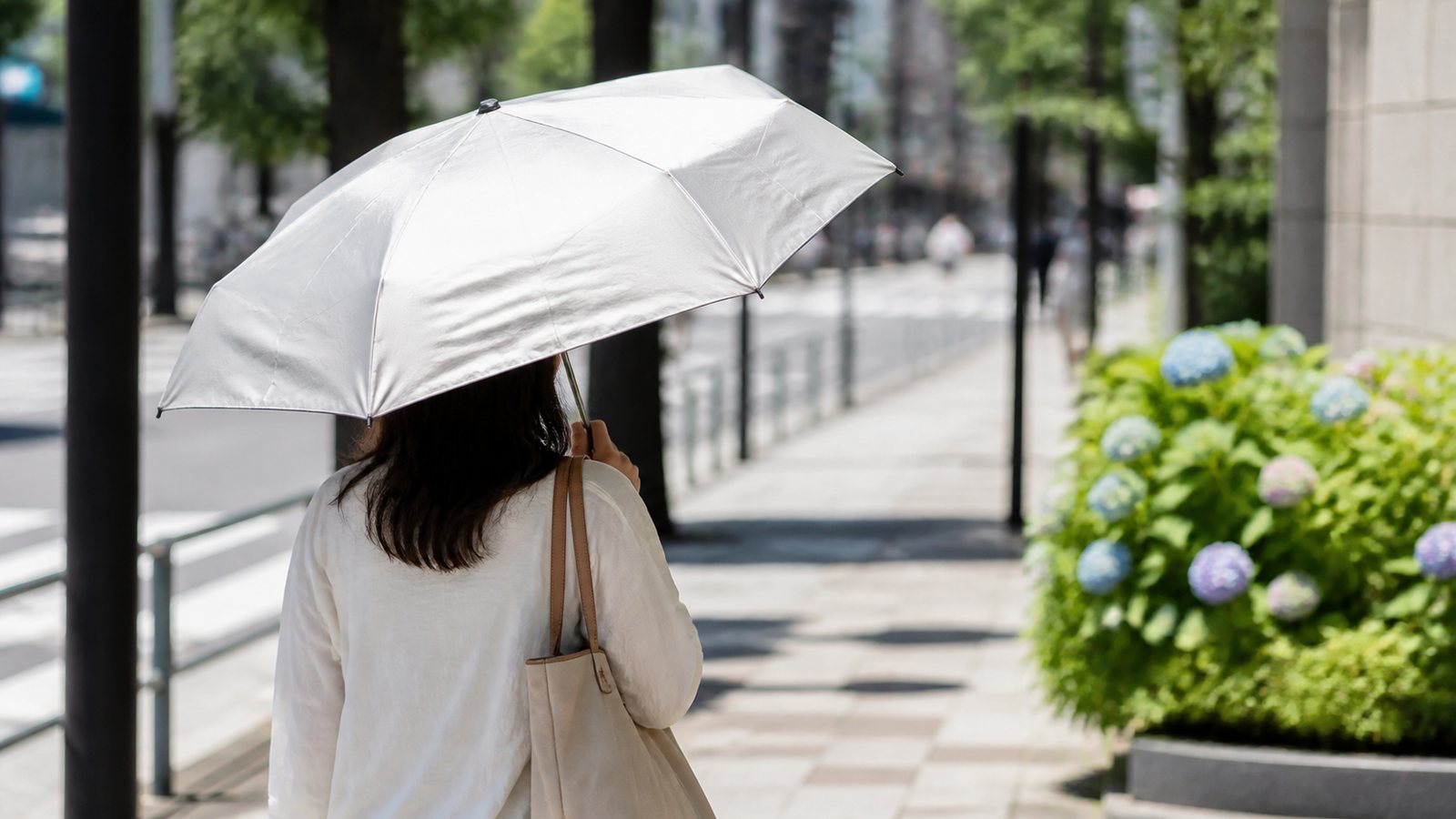 Compact UV umbrella used on a bright Japanese summer street