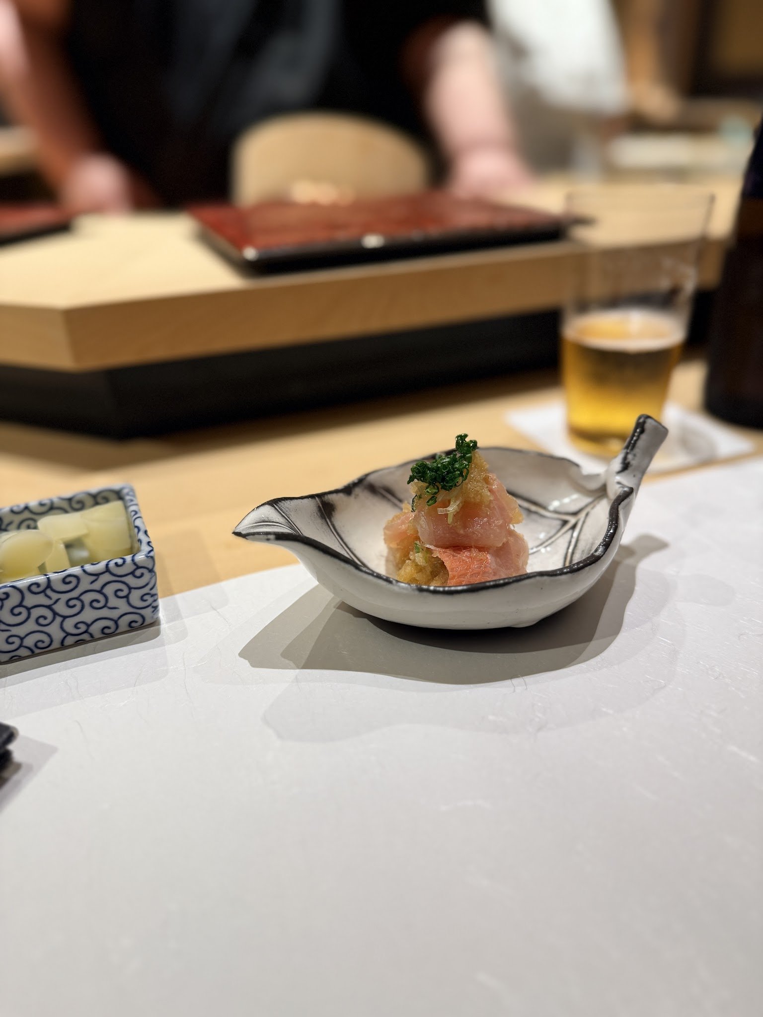 Golden eye snapper dressed with grated radish ponzu in a leaf-shaped dish