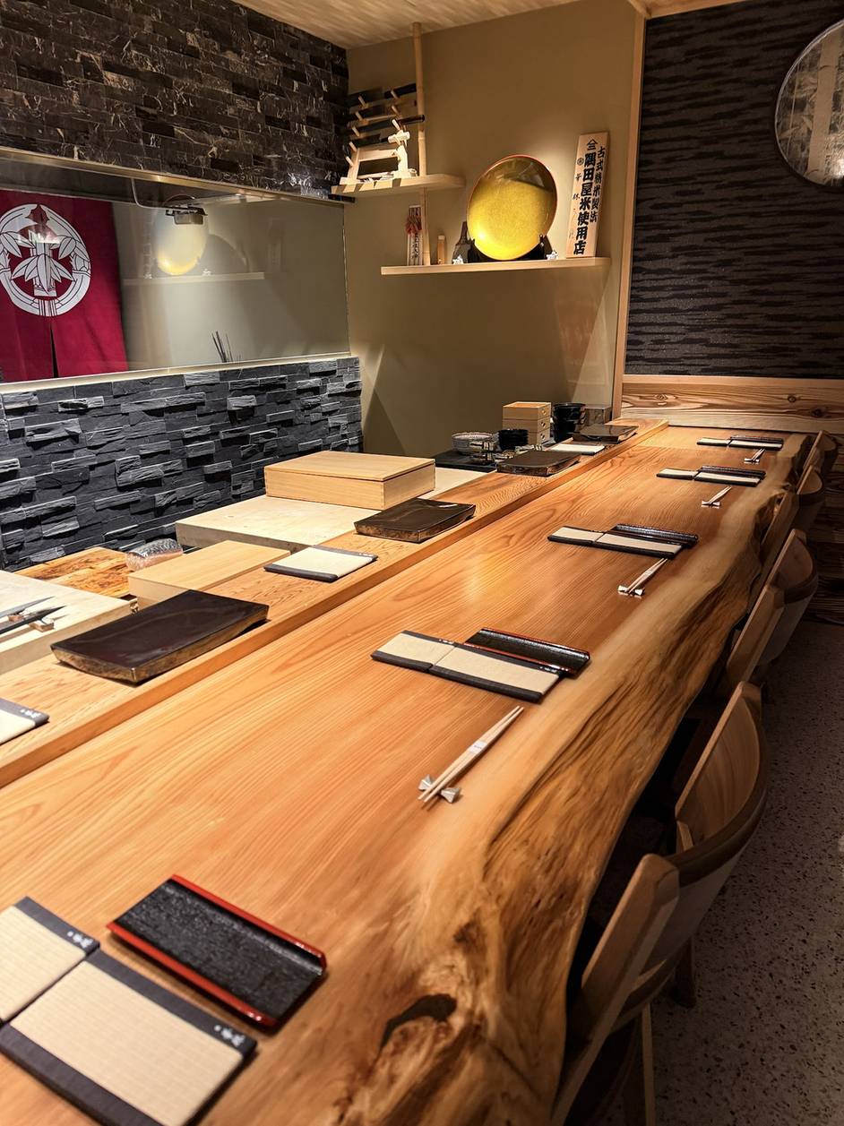 The Yakusugi cedar single-plank counter set with place settings at Karin