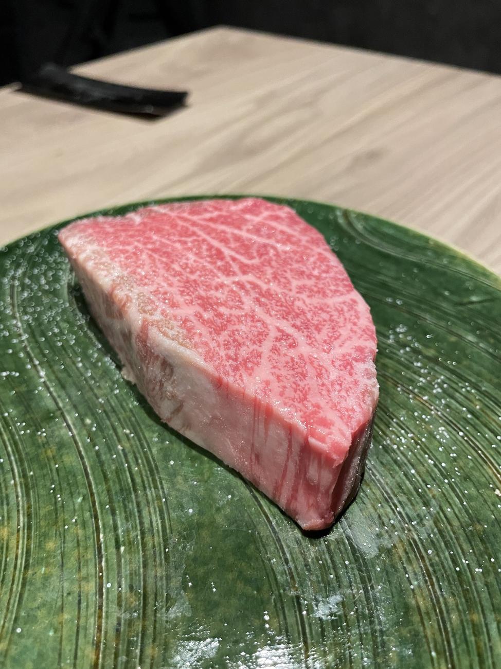 Thick marbled wagyu beef on a green leaf plate at GYU CHIBA
