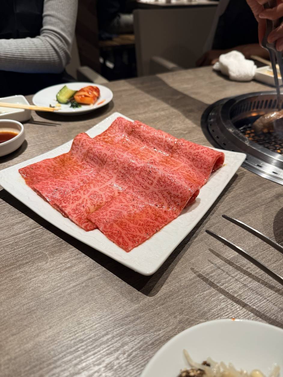 Beautifully marbled chu-toro wagyu loin on a white plate