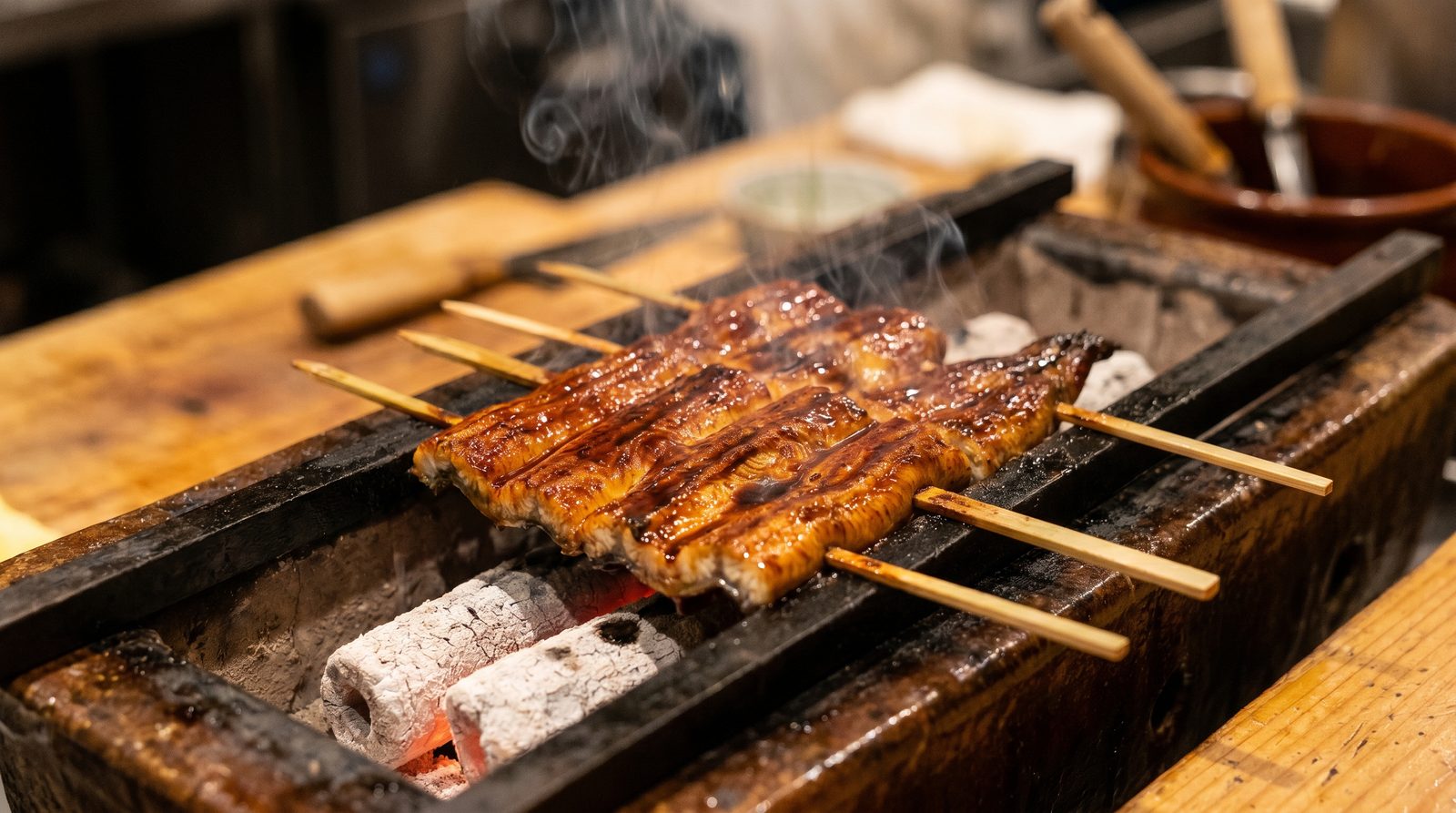 Unagi kabayaki grilling over charcoal on skewers
