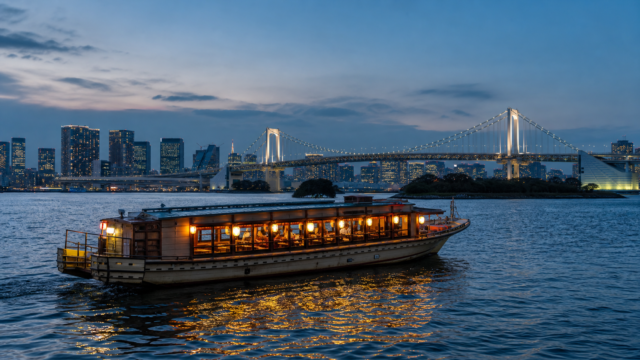 Traditional Tokyo yakatabune boat on an illuminated waterfront at night