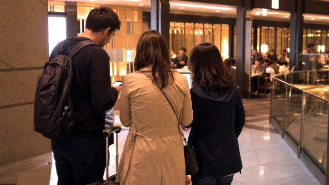 Tourists checking dinner options near a Tokyo station after a failed restaurant reservation.