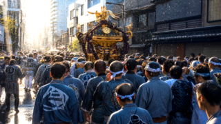 Mikoshi carriers and spectators on a wet Tokyo summer festival street.