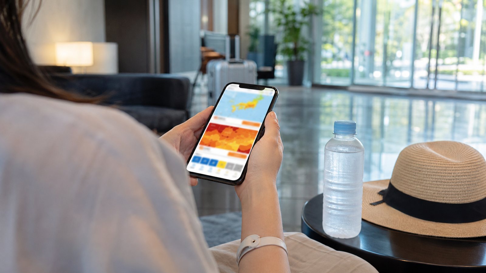 Traveler checking heat information on a smartphone in a hotel lobby