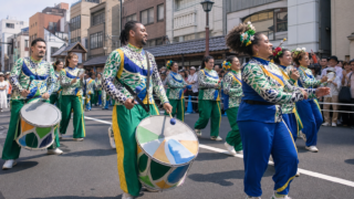 Samba dancers and musicians performing on a crowded street in Asakusa