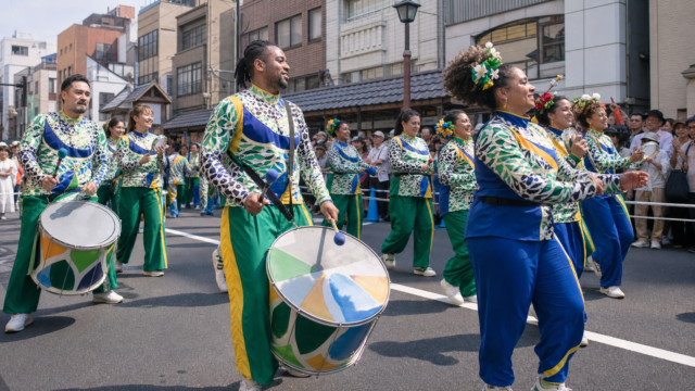 Samba dancers and musicians performing on a crowded street in Asakusa