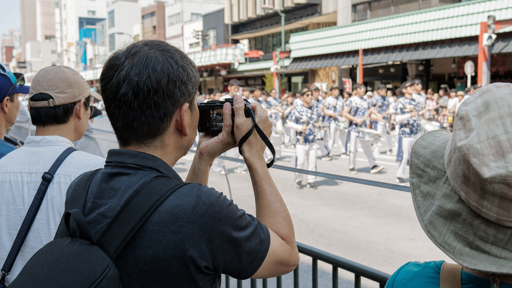 Spectator photographing a samba performance with a small handheld camera