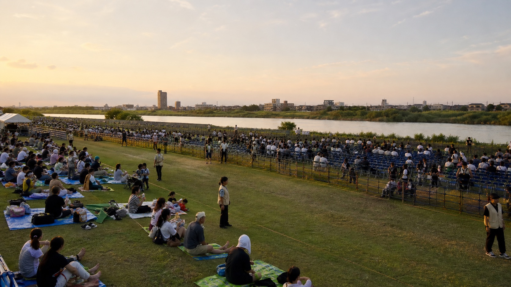 Visitors choosing spaces in a riverside viewing area before sunset