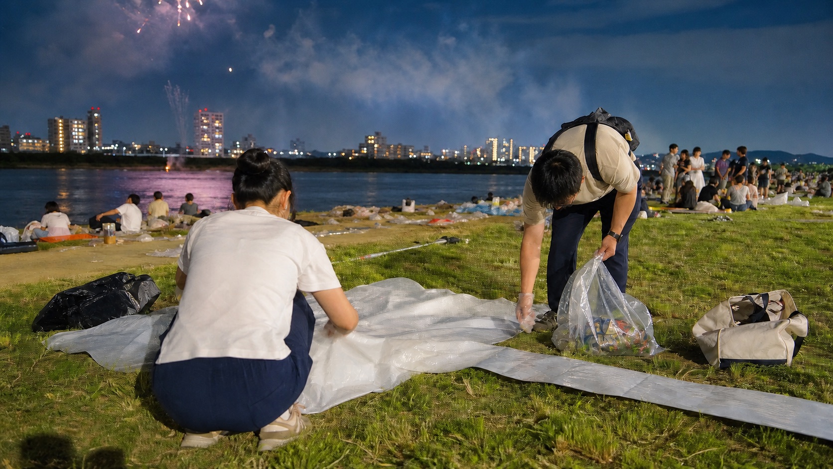 Visitors cleaning their viewing area after a Japanese fireworks festival