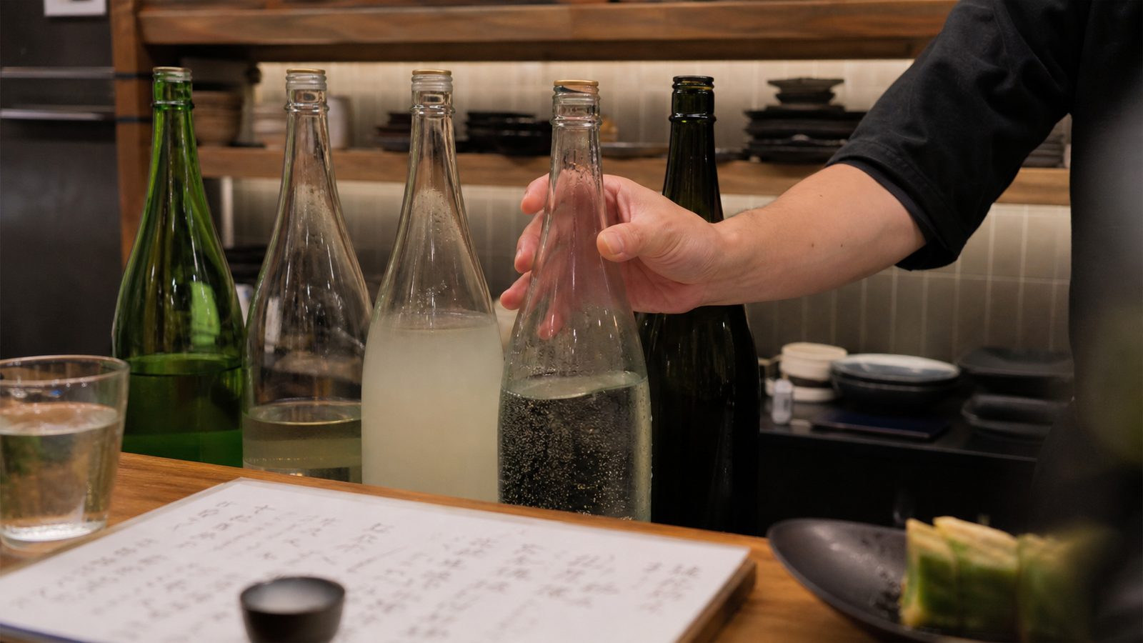 Clear, cloudy and sparkling sake styles arranged at a restaurant counter