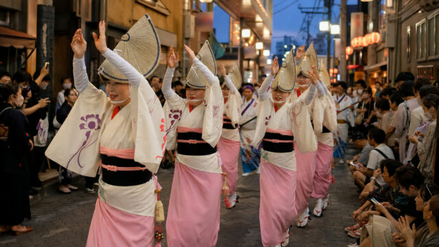 Awa Odori dancers moving through a Koenji shopping street at dusk