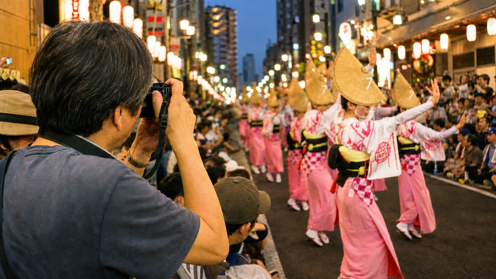 A spectator taking a handheld photo of Awa Odori dancers