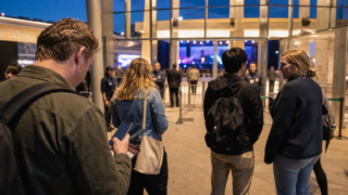 International visitors preparing a mobile ticket and passport at a Japanese live-event entrance