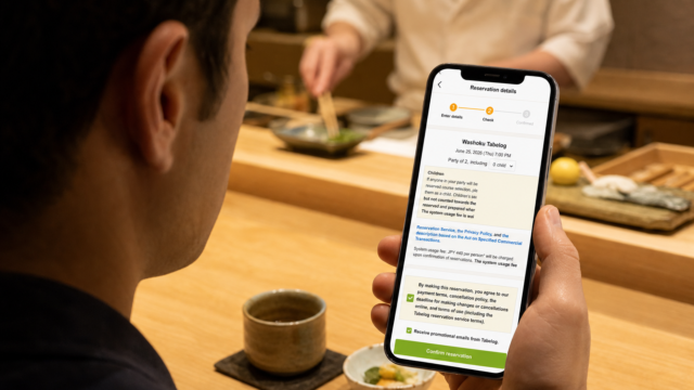 Traveler checking the Tabelog English reservation details screen at a Japanese restaurant