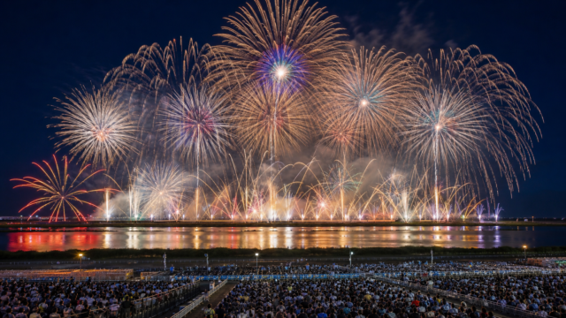 Large competition fireworks over the Omagari riverside seating area at night