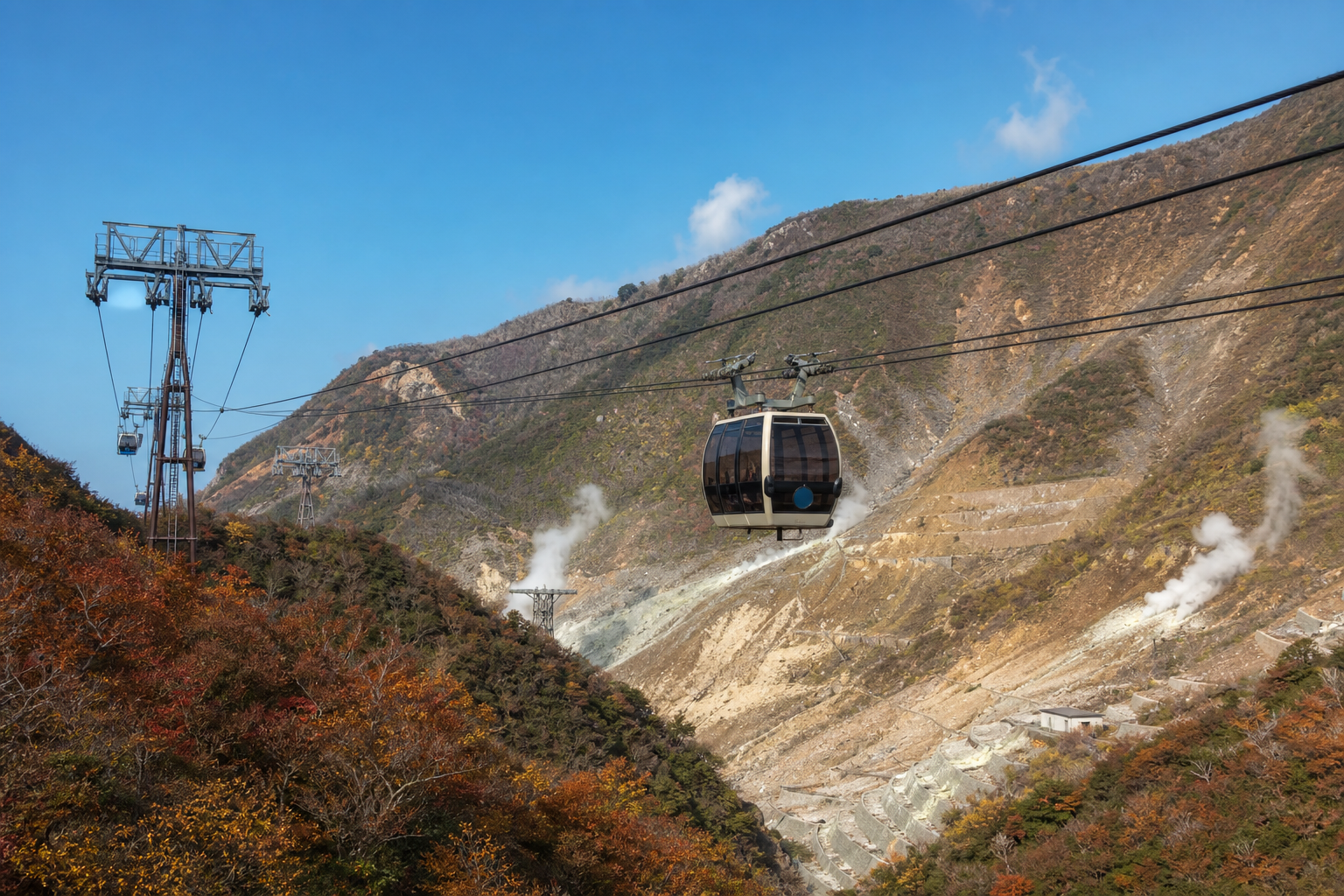 Hakone ropeway gondolas passing over the volcanic Owakudani landscape in autumn