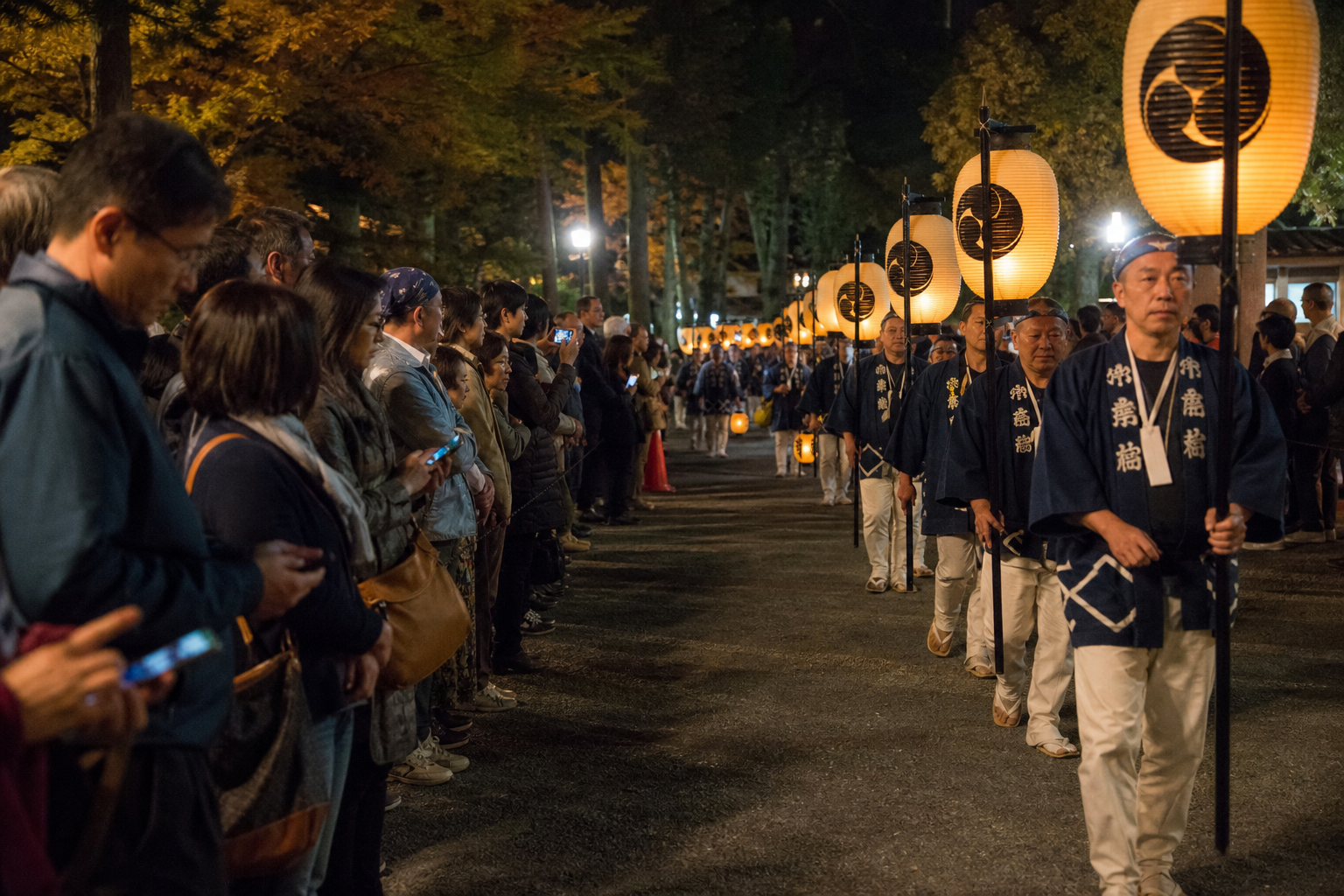 Spectators respectfully watching a lantern procession from the route edge
