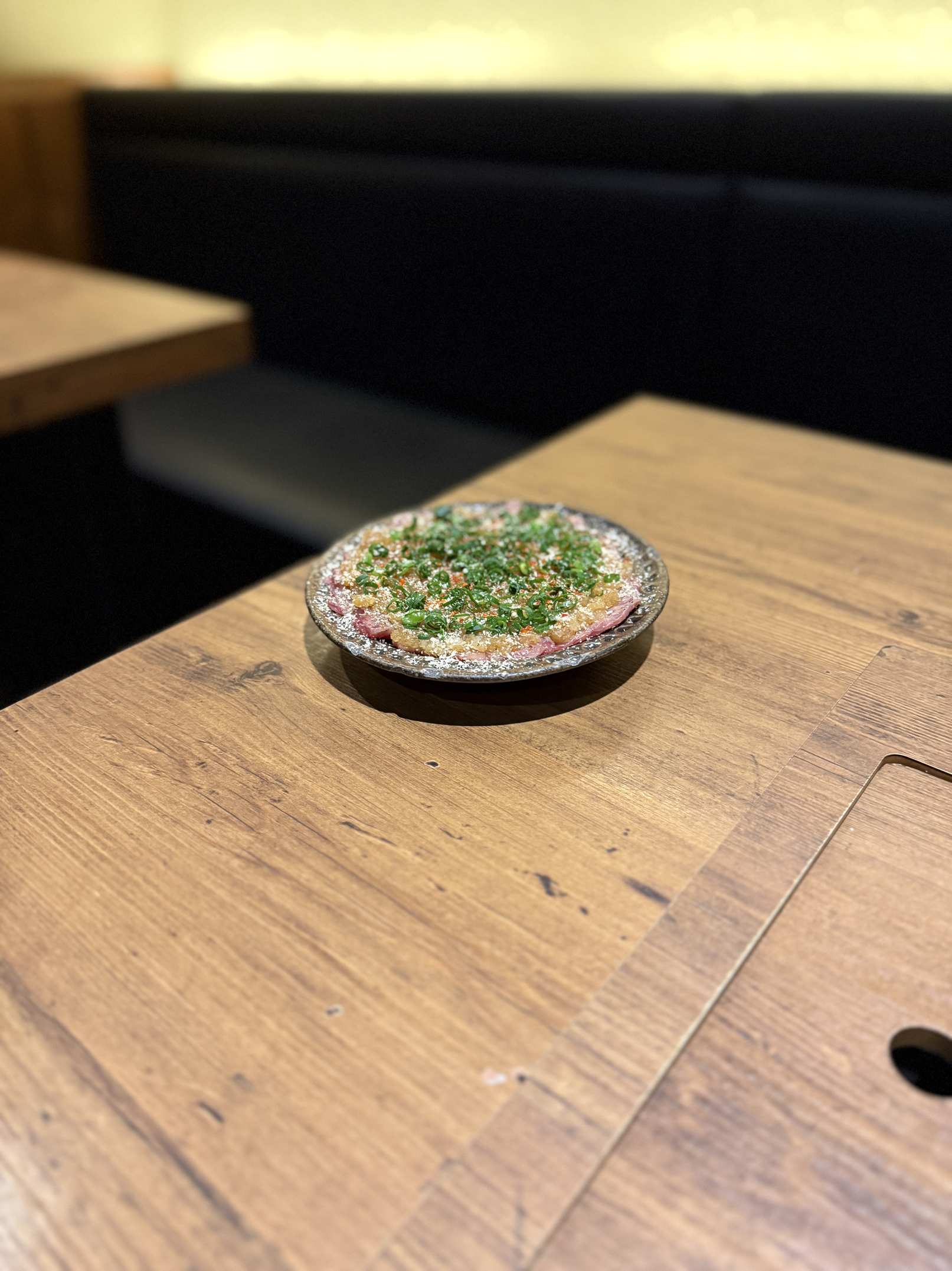 Thin slices of beef topped with chopped green onion sauce