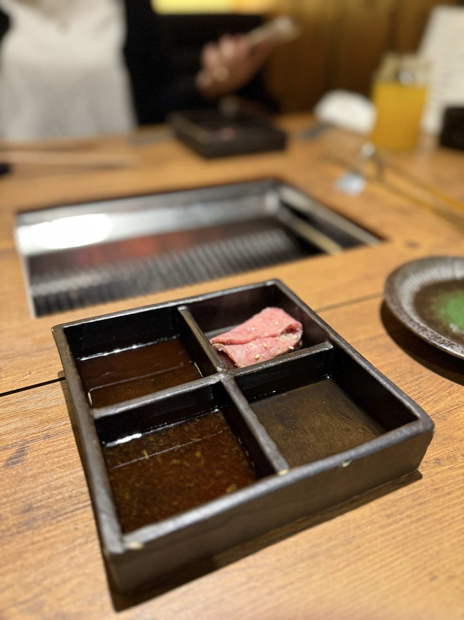 Grilled beef resting in a divided sauce tray