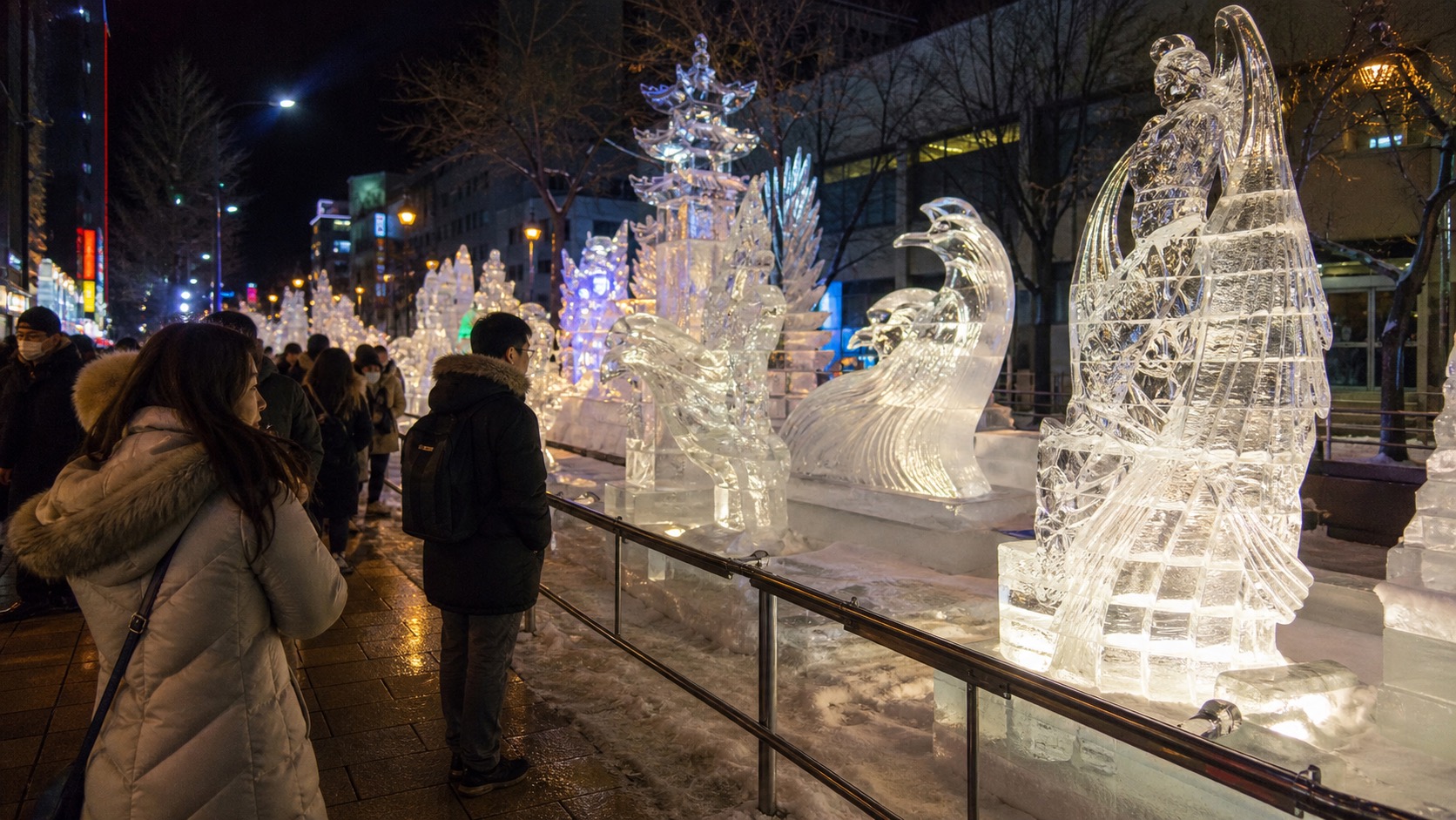 Illuminated ice sculptures along a winter street in Susukino