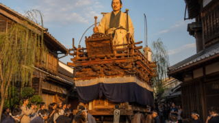 AI-generated illustration of a large traditional festival float moving through a historic Sawara-style street