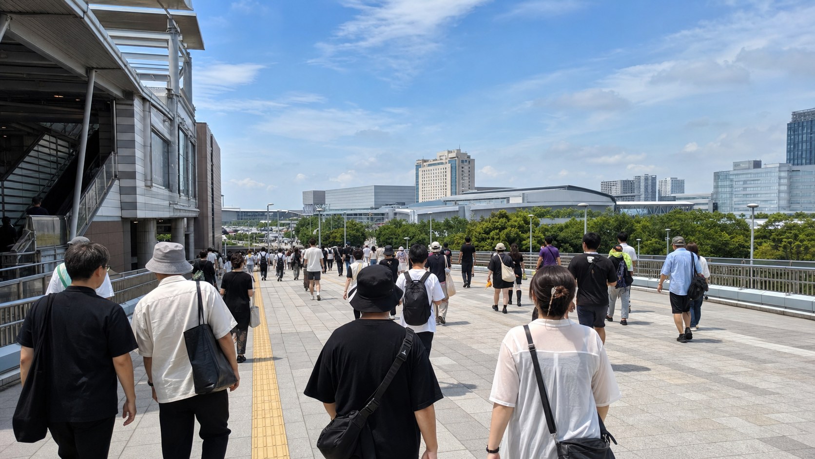 Festival visitors walking from a suburban Japanese station toward low exhibition halls in summer