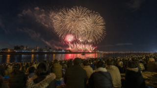 Autumn fireworks over the Sakuragawa riverbank with bundled spectators