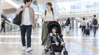 Parent with a compact stroller in a bright Japanese station concourse