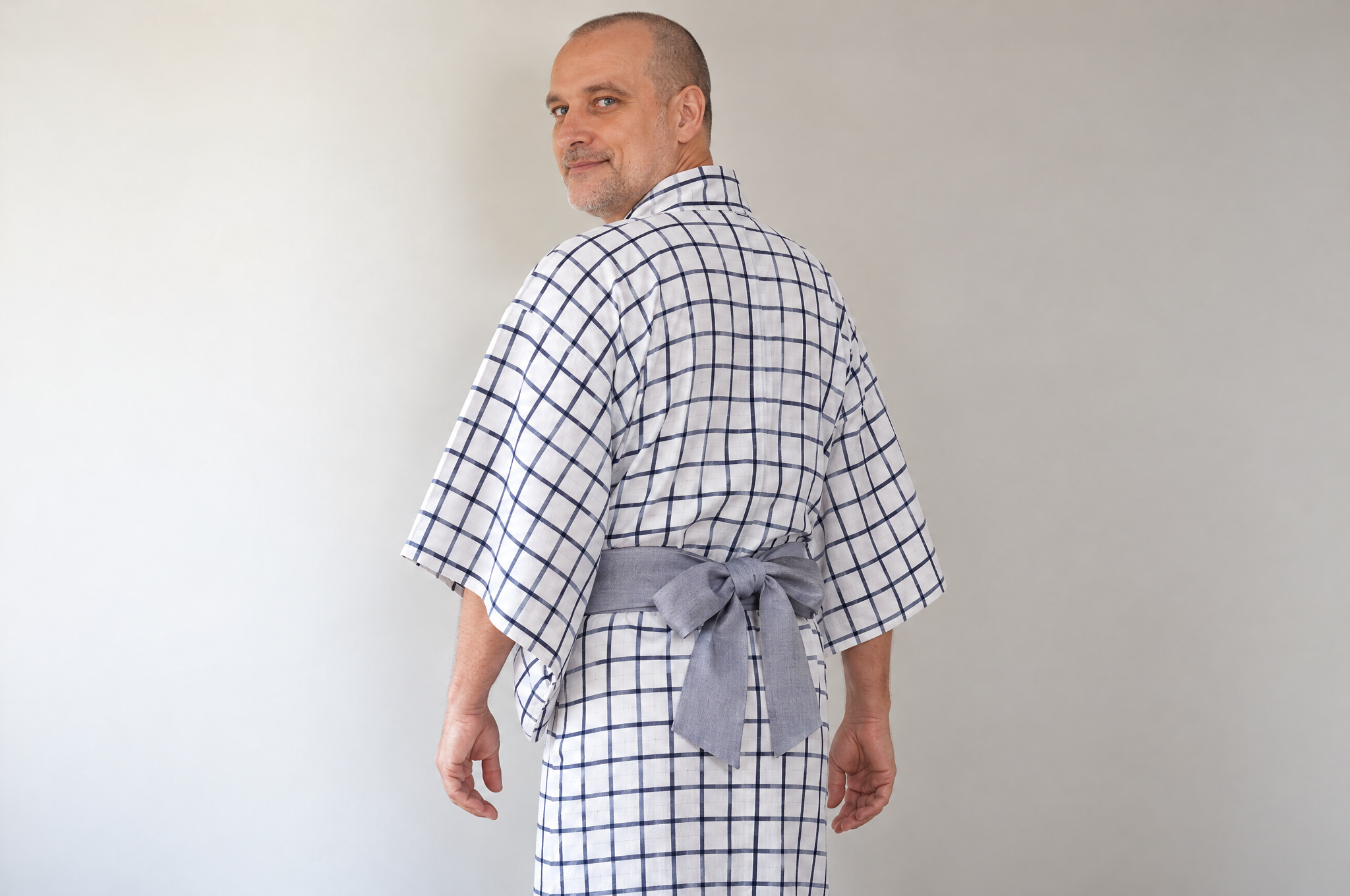 Two-loop bow in a soft gray sash at the back of a man's yukata
